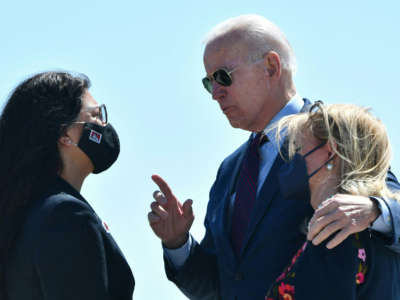 President Joe Biden puts his arm around Rep. Debbie Dingell as he speaks to Rep. Rashida Tlaib, left, upon arrival at Detroit Metropolitan Wayne County Airport in Detroit, Michigan, on May 18, 2021.