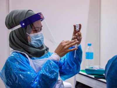 A medical worker fills a syringe with the covid vaccine