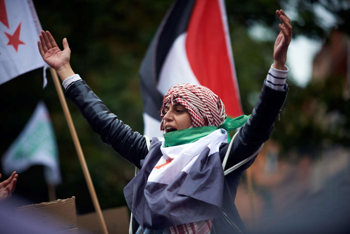 An activist raises their hands during a demonstration in support of Palestine