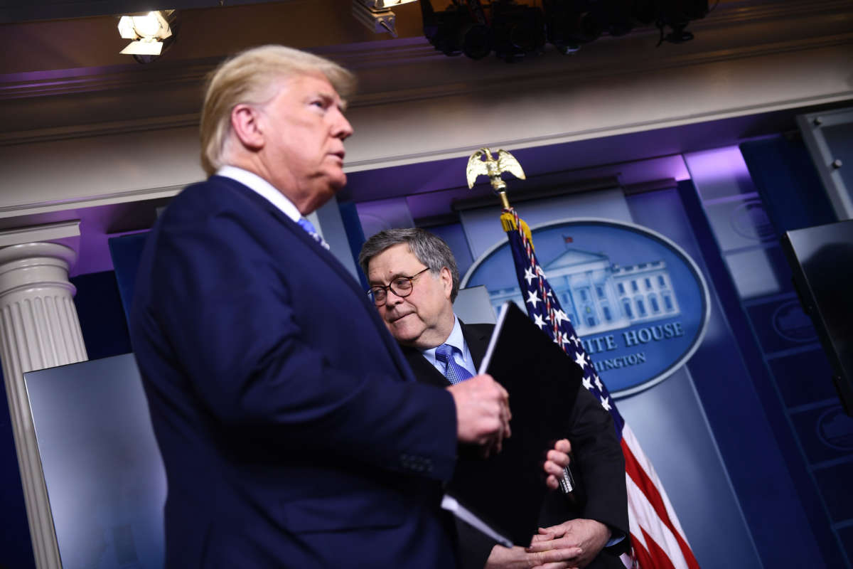 President Donald Trump arrives as Attorney General William Barr looks on during a briefing at the White House on March 23, 2020, in Washington, D.C.