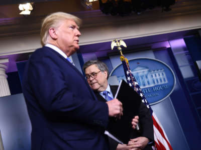 President Donald Trump arrives as Attorney General William Barr looks on during a briefing at the White House on March 23, 2020, in Washington, D.C.