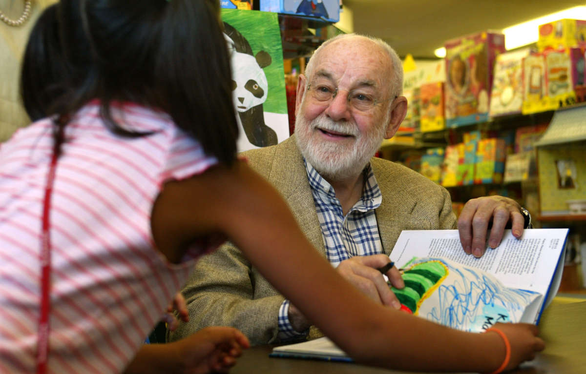 Eric Carle, one of the giants in the field of children's books and author/illustrator of The Very Hungry Caterpillar, signs a book for a young fan at San Marino Toy and Booke Shoppe on August 20, 2003.