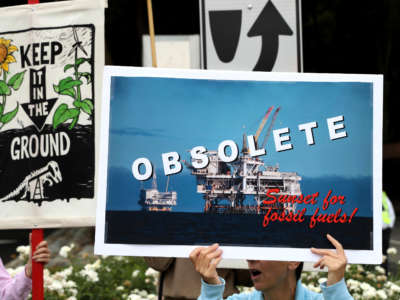 A climate activist holds a sign during a Climate Strike youth protest outside of Chevron headquarters on September 27, 2019, in San Ramon, California.