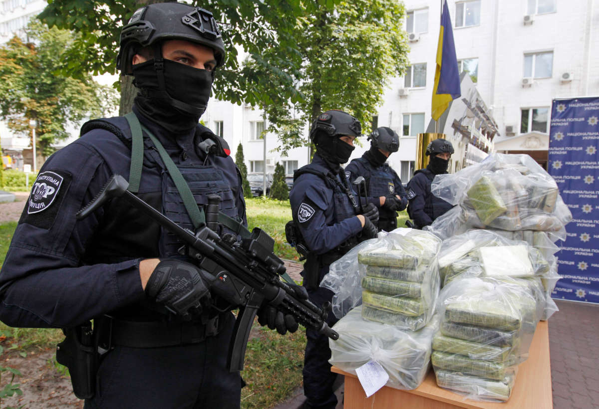 Police officers stand on guard next to bags of cocaine, which were seized during a special police operation, at a press conference of the National Police and the Anti-Narcotic Police Department and the U.S. Department of the Drug Enforcement Administration (DEA) in the Ministry of Internal Affairs in Kiev, Ukraine, on July 2, 2019.