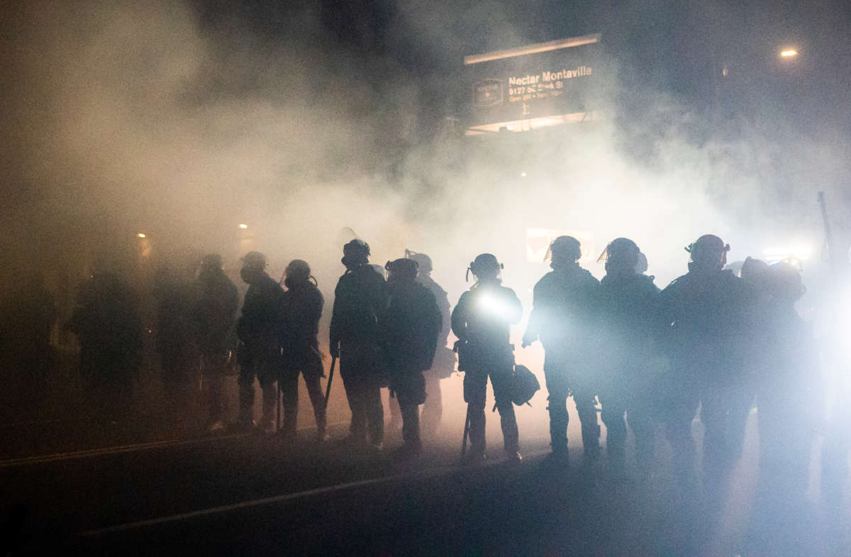 Oregon State Troopers and Portland police advance through tear gas while dispersing a protest against police brutality and racial injustice on September 5, 2020, in Portland, Oregon.