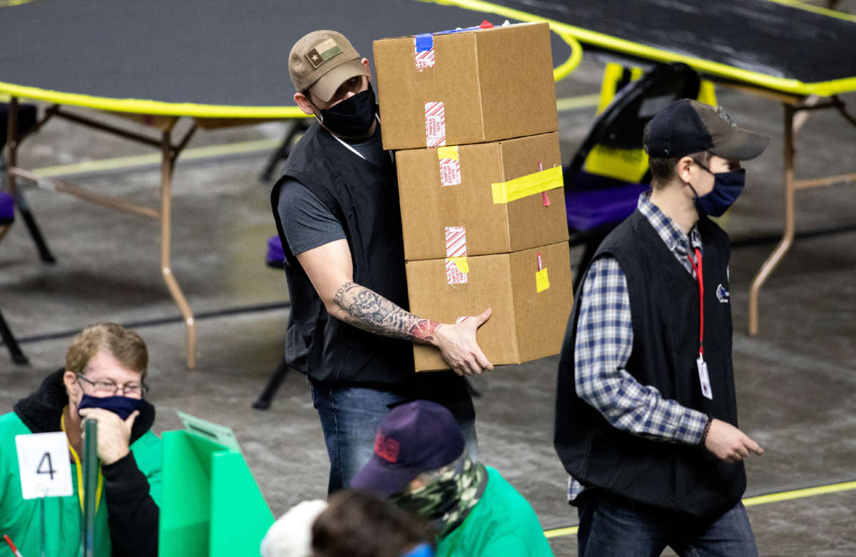 Contractors working for Cyber Ninjas, who were hired by the Arizona State Senate, examine and recount ballots from the 2020 general election at Veterans Memorial Coliseum on May 1, 2021, in Phoenix, Arizona.