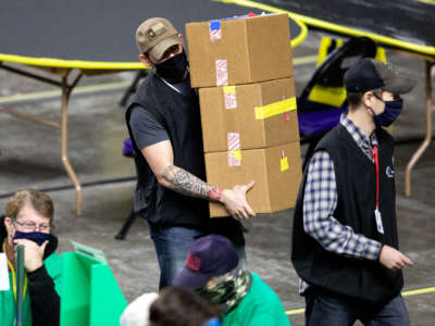 Contractors working for Cyber Ninjas, who were hired by the Arizona State Senate, examine and recount ballots from the 2020 general election at Veterans Memorial Coliseum on May 1, 2021, in Phoenix, Arizona.