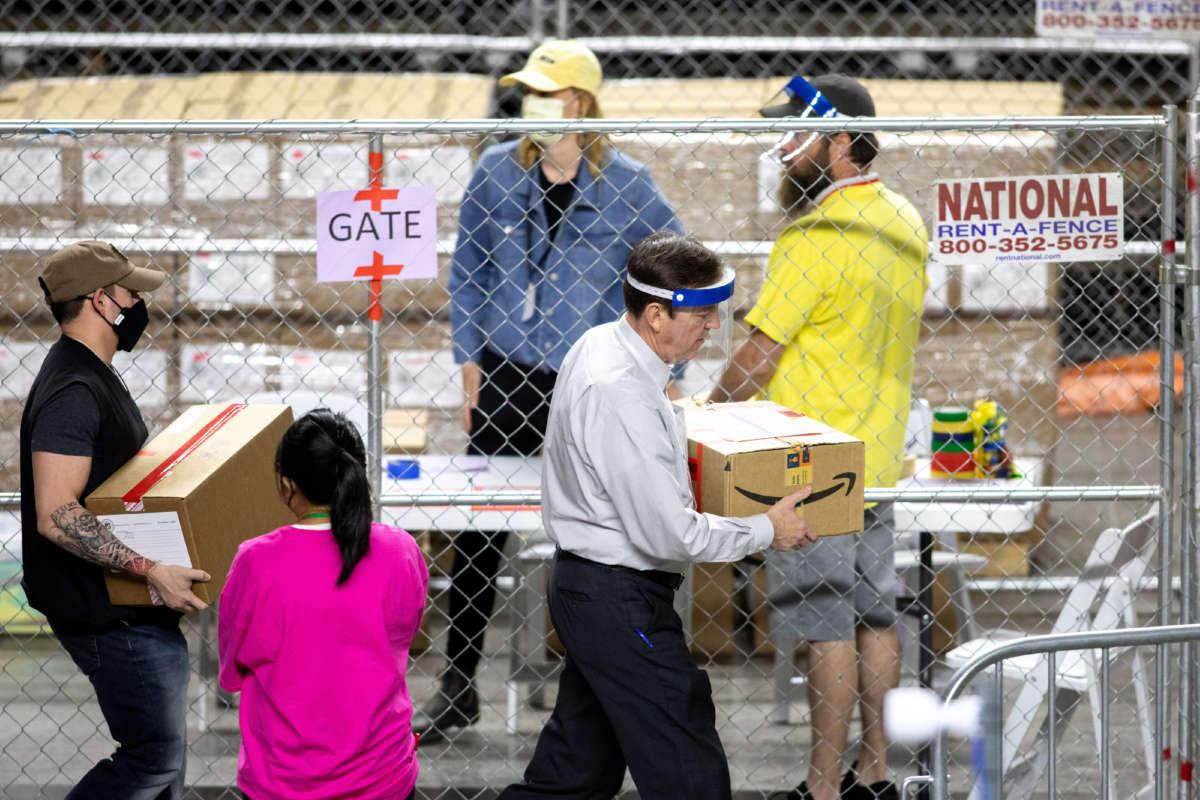 Former Secretary of State Ken Bennett, right, works to move ballots from the 2020 general election at Veterans Memorial Coliseum on May 1, 2021, in Phoenix, Arizona. The Maricopa County ballot recount comes after two election audits found no evidence of widespread fraud in Arizona.