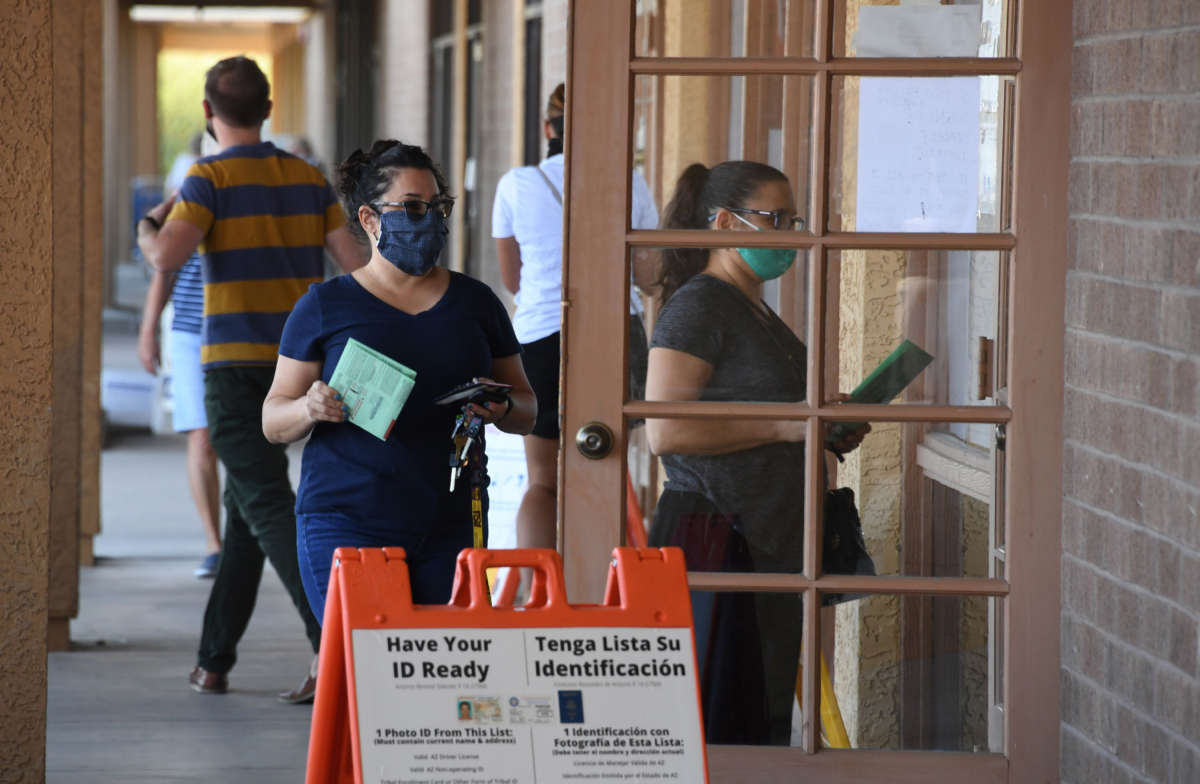 People arrive either to drop off mail-in ballots or vote in person in the U.S. presidential election at an early voting location in Phoenix, Arizona, on October 16, 2020.