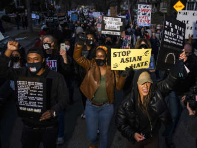 People march through a neighborhood to protest against anti-Asian violence on March 18, 2021, in Minneapolis, Minnesota.