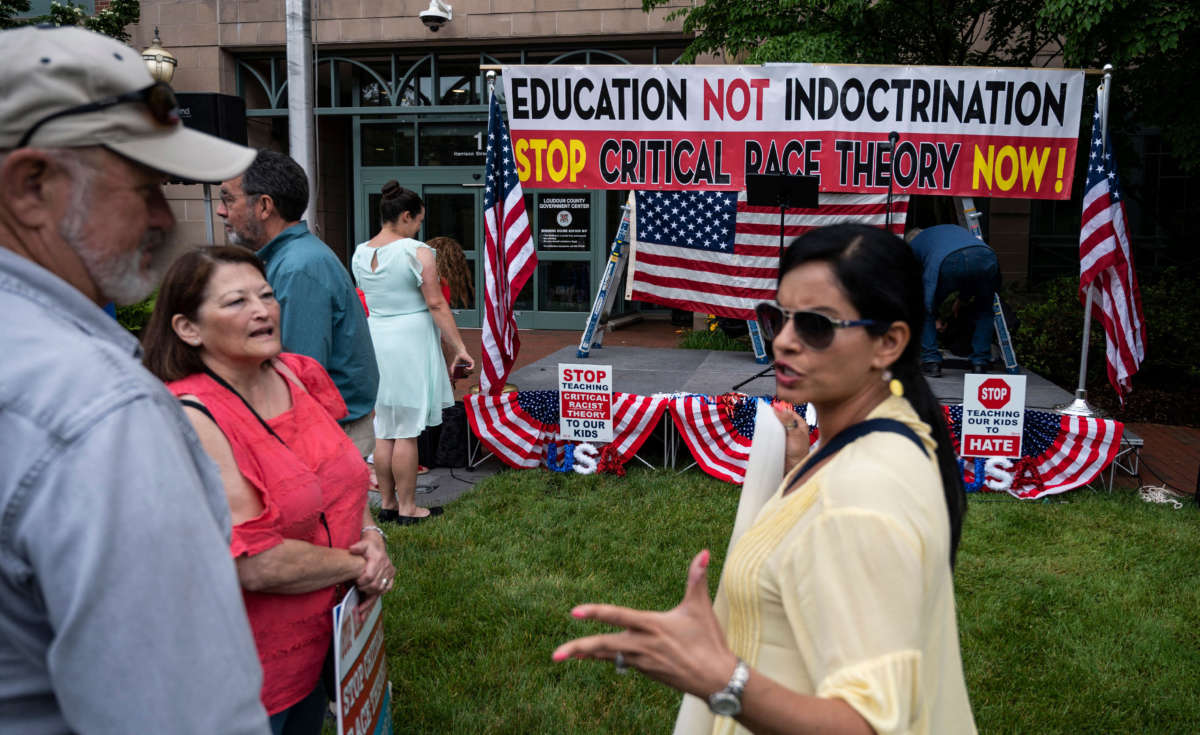 People talk before the start of a rally against "critical race theory" being taught in schools at the Loudoun County Government center in Leesburg, Virginia, on June 12, 2021.
