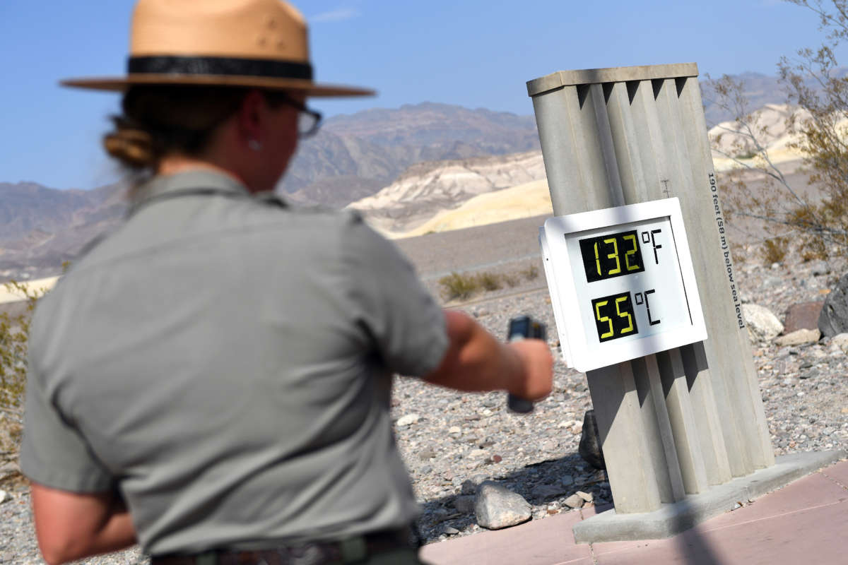 U.S. Park Ranger Jeannette Jurado takes a surface temperature reading from an unofficial thermometer reading 132 degrees Fahrenheit/55 degrees Celsius at Furnace Creek Visitor Center on July 11, 2021, in Death Valley National Park, California.