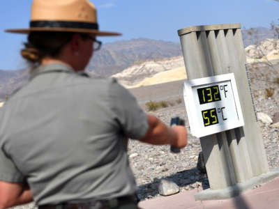 U.S. Park Ranger Jeannette Jurado takes a surface temperature reading from an unofficial thermometer reading 132 degrees Fahrenheit/55 degrees Celsius at Furnace Creek Visitor Center on July 11, 2021, in Death Valley National Park, California.