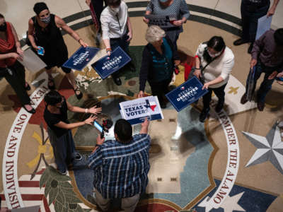 People opposed to the Texas Republican-led effort to pass new voting restrictions are gathered at the State Capitol as they wait to testify before state lawmakers who began committee hearings on election integrity bills on July 10, 2021, in Austin, Texas.