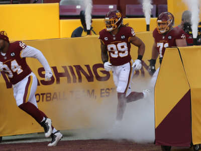 Washington Football Team members run onto the field on December 27, 2020, at FedEx Field in Landover, Maryland.