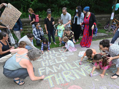 Parents and children celebrate new monthly Child Tax Credit payments and urge congress to make them permanent outside Sen. Chuck Schumer's home on July 12, 2021, in Brooklyn, New York.