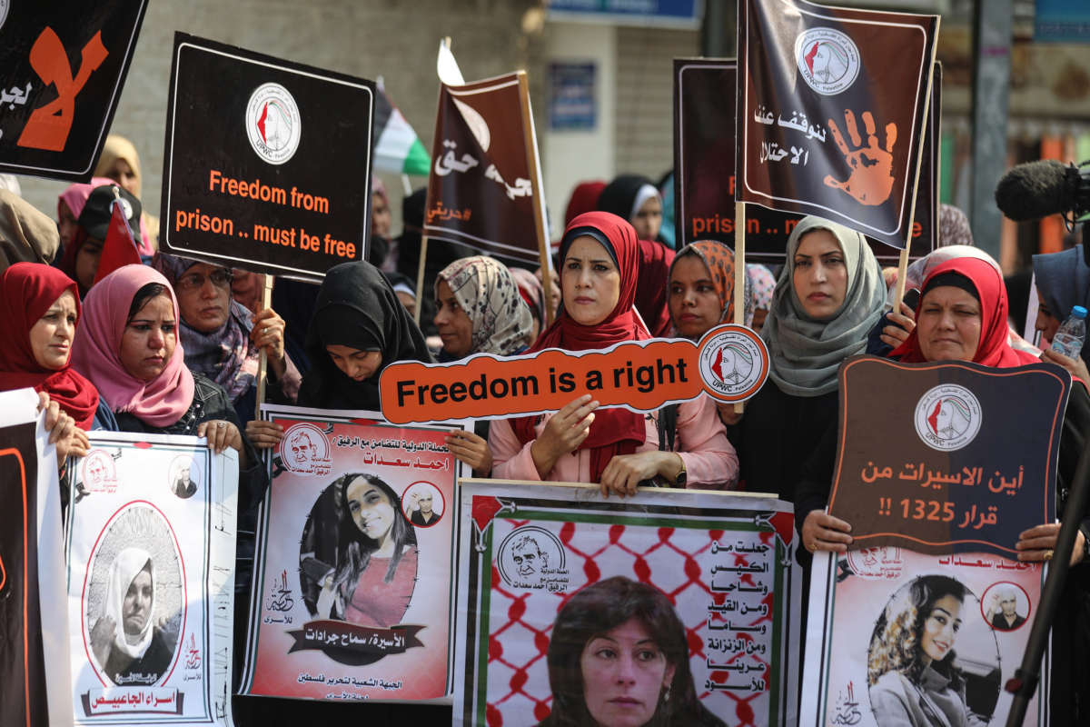 Palestinian women hold placards as they gather for a demonstration in support of Palestinian woman prisoners in Israeli jails in front of the International Committee of the Red Cross building in Gaza City, Gaza, on November 6, 2019.