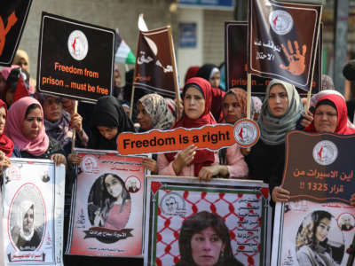 Palestinian women hold placards as they gather for a demonstration in support of Palestinian woman prisoners in Israeli jails in front of the International Committee of the Red Cross building in Gaza City, Gaza, on November 6, 2019.