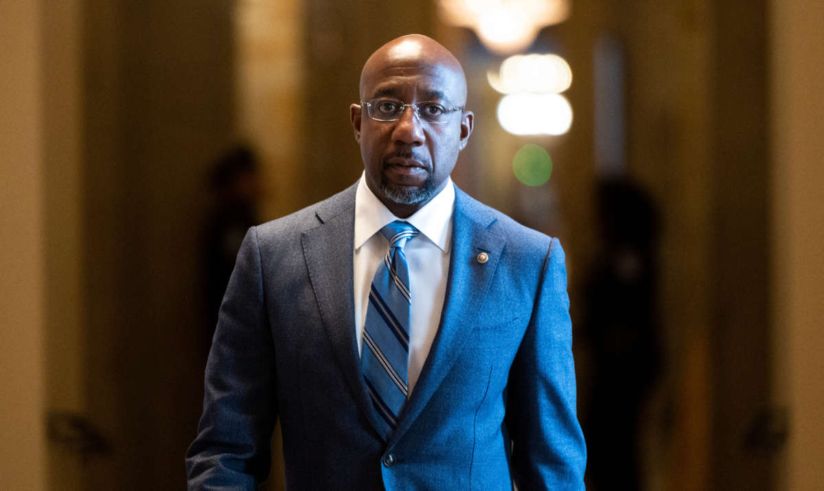 Sen. Raphael Warnock walks in the Capitol on July 13, 2021.