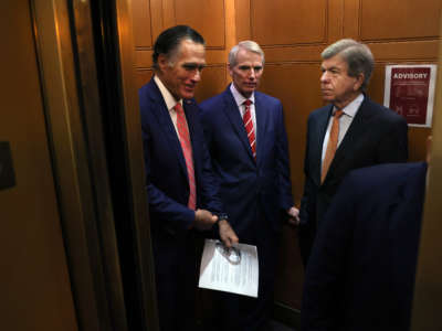 From left, Sens. Mitt Romney, Rob Portman and Roy Blunt ride an elevator as they leave a bipartisan meeting on infrastructure at the U.S. Capitol on July 13, 2021, in Washington, D.C.
