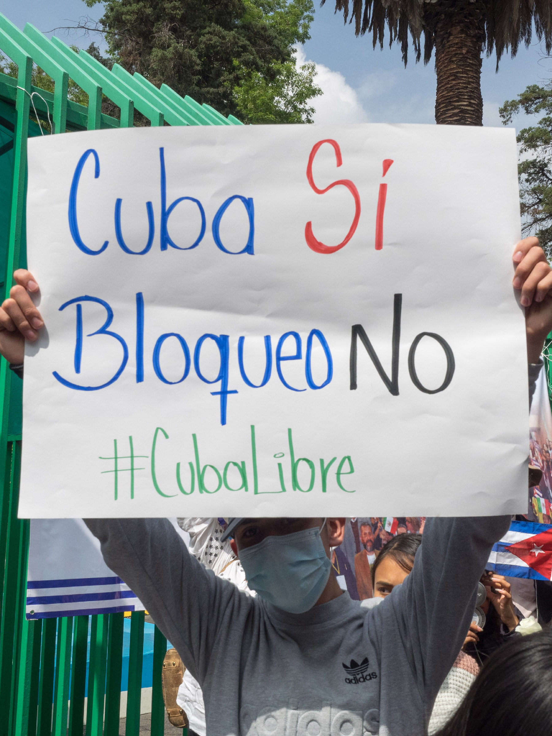 A demonstrator holds up a sign that reads "Cuba Yes, Blockade No" during a demonstration in solidarity with the Cuban Revolution in front of the Cuban embassy in Mexico City, Mexico, July 17, 2021.