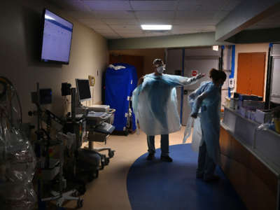 Hospital staff suit up with PPE in the COVID-19 section before entering the ward to work with patients in Tampa, Florida, on August 19, 2020.