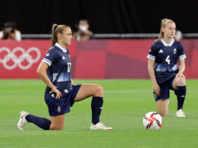 Britain's forward Georgia Stanway, left, and midfielder Keira Walsh take a knee before the Tokyo 2020 Olympic Games women's group E first round football match between Great Britain and Chile at the Sapporo Dome in Sapporo on July 21, 2021.