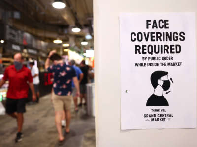 A sign is posted about required face coverings in Grand Central Market on July 19, 2021, in Los Angeles, California.