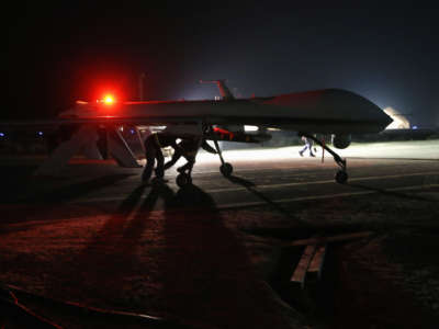 Contract workers push a U.S. Air Force MQ-1B Predator unmanned aerial vehicle after it flew a mission from an air base in the Persian Gulf region on January 7, 2016.