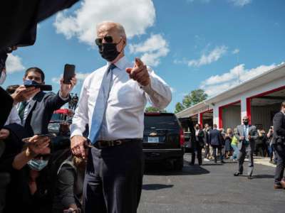 Joe Biden points while glaring through his aviator sunglasses