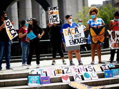 People attend a protest and display signs in support of DACA (Deferred Action for Childhood Arrivals)