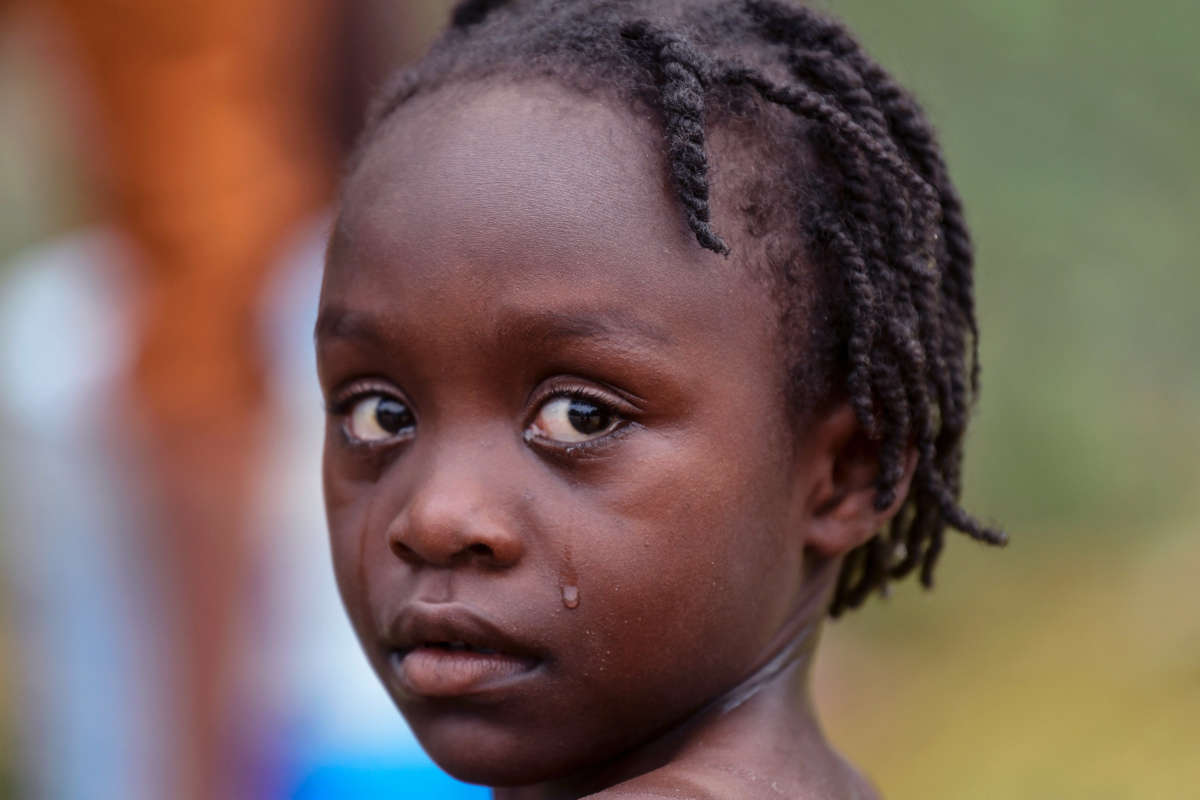 A little girl cries while looking into the camera