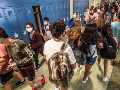 Students walk through the hallway wearing masks as they return to class on the first day of school at the Jericho, New York, school district on August 26, 2021.