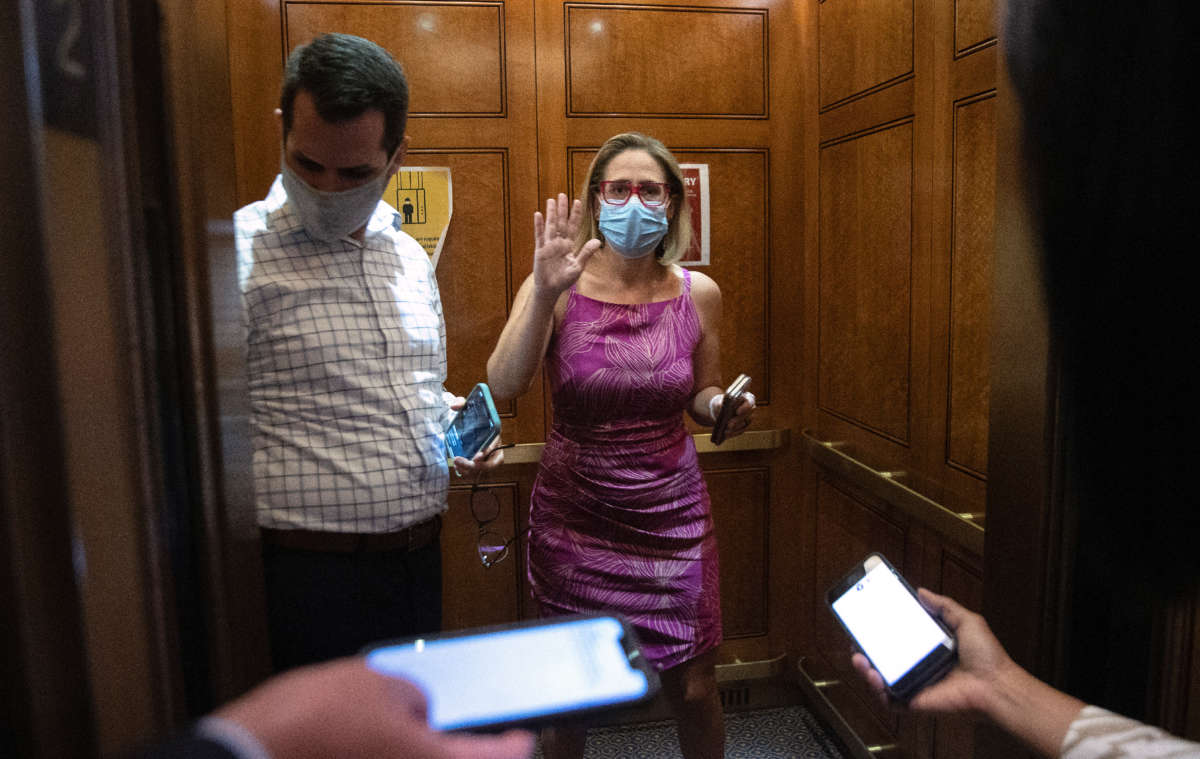 Sen. Kyrsten Sinema speaks briefly to reporters as she boards an elevator following votes at the U.S. Capitol on September 20, 2021, in Washington, D.C.