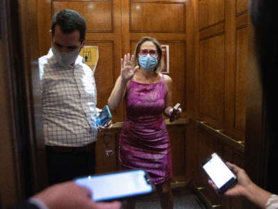 Sen. Kyrsten Sinema speaks briefly to reporters as she boards an elevator following votes at the U.S. Capitol on September 20, 2021, in Washington, D.C.