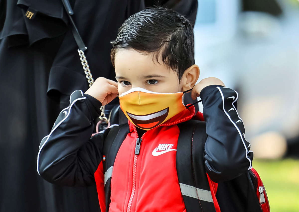 A student puts on a mask at Philip Rogers Elementary School in Chicago, Illinois, on August 30, 2021.