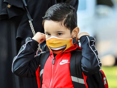 A student puts on a mask at Philip Rogers Elementary School in Chicago, Illinois, on August 30, 2021.