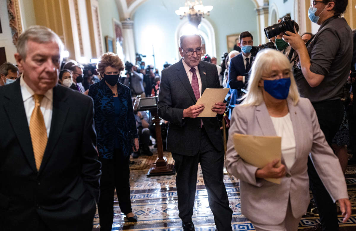 Senate Majority Leader Charles Schumer (center) leaves after speaking to reporters following a Democratic policy luncheon at the U.S. Capitol on September 28, 2021, in Washington, D.C.