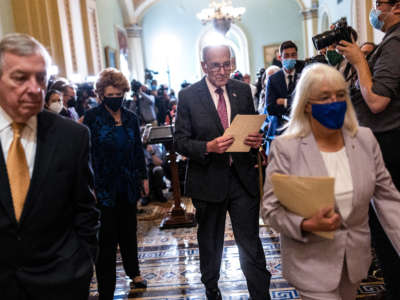 Senate Majority Leader Charles Schumer (center) leaves after speaking to reporters following a Democratic policy luncheon at the U.S. Capitol on September 28, 2021, in Washington, D.C.