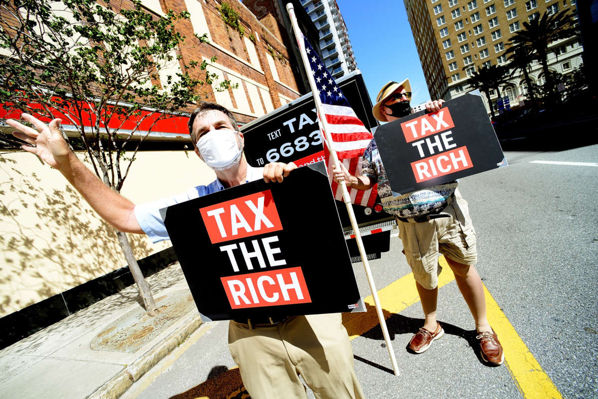 John Stewart, left, and Jay Alexander of MoveOn call on Senator Marco Rubio's office to increase federal taxes to big corporations on May 17, 2021, in Tampa, Florida.