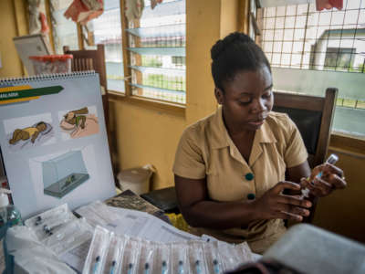 A nurse takes a vaccine from a bottle to administrate it to a child at Ewim Polyclinic on April 30, 2019. Ewim Polyclinic was the first in Ghana to roll out the malaria vaccine Mosquirix.