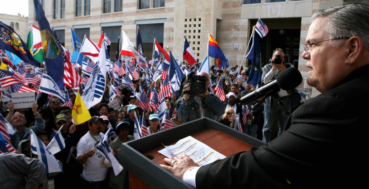 Pastor John Hagee addresses a crowd of his followers as they wave Israeli and US flags during a rally in downtown Jerusalem on April 7, 2008.