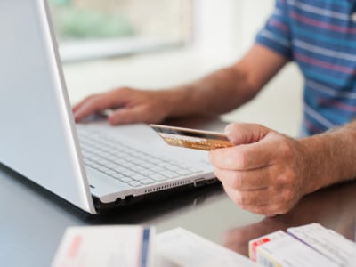 Close up of man using credit card to purchase merchandise online