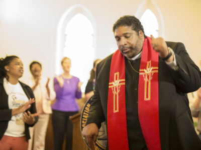 The Rev. William J. Barber II joins in song at the conclusion of a press conference held by the state NAACP at Davie Street Presbyterian Church in Raleigh, North Carolina on May 15, 2017. Barber stepped down as the state NAACP president to help lead a new national Poor People's Campaign.