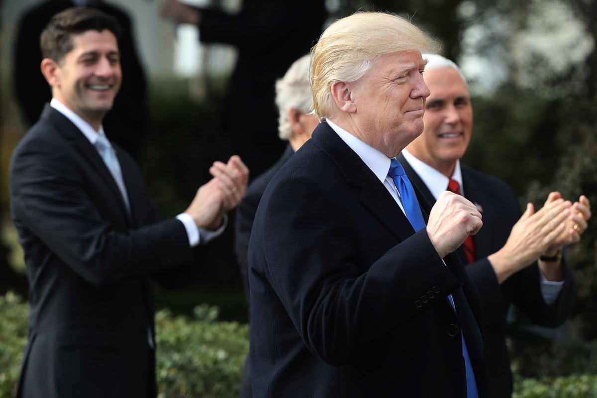 President Donald Trump pumps his fist during an event to celebrate Congress passing the Tax Cuts and Jobs Act with Republican members of the House and Senate on the South Lawn of the White House December 20, 2017, in Washington, DC.