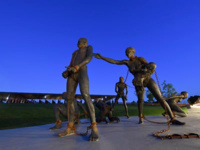 A sculpture by artist Kwame Akoto-Bamfo, part of the Nkyinkyim Installation, of enslaved people in chains is shown after entering The National Memorial for Peace and Justice on April 20, 2018, in Montgomery, Al.