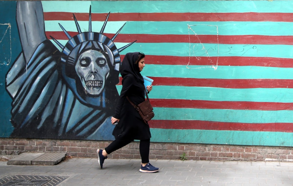 A woman passes a mural painted on the wall of the former US Embassy in Tehran, Iran, on May 9, 2018.