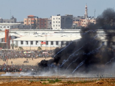 A picture taken on May 14, 2018, from the southern Israeli kibbutz of Nahal Oz across the border with the Gaza Strip shows tear gas canisters launched by Israeli forces falling down on Palestinian protesters gathering along the border fence with Israel. Dozens of Palestinians were killed by Israeli fire on May 14 as tens of thousands protested the US transfer of its embassy to Jerusalem.