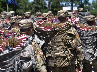 Members of the Old Guard arrive with packs full of US flags to place on graves at Arlington National Cemetery on May 24, 2018, ahead of Memorial Day in Arlington, Virginia.