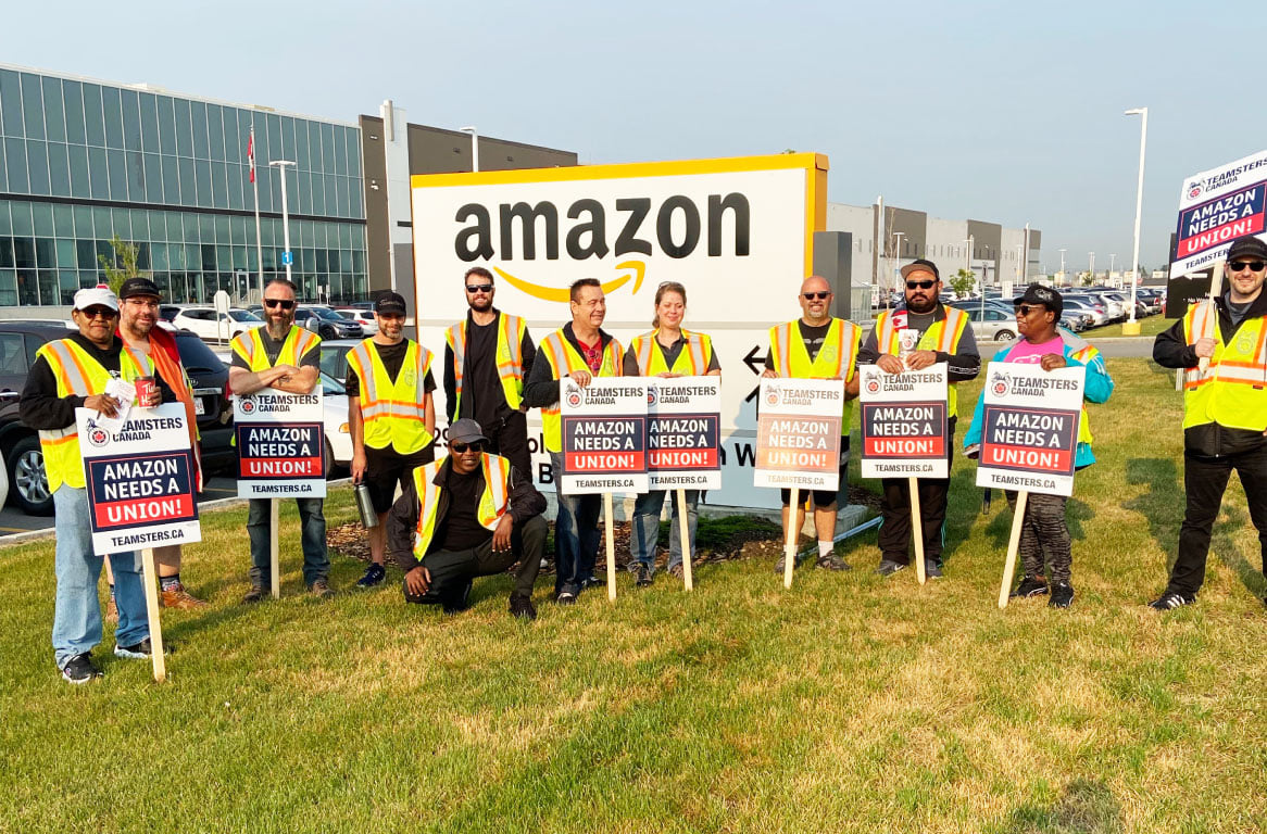 Members of Teamsters Locals 987 and 362 protest outside an Amazon fulfillment center in Alberta, Canada, on July 14, 2021, after meeting with Amazon workers across the country to discuss working conditions and union organizing.